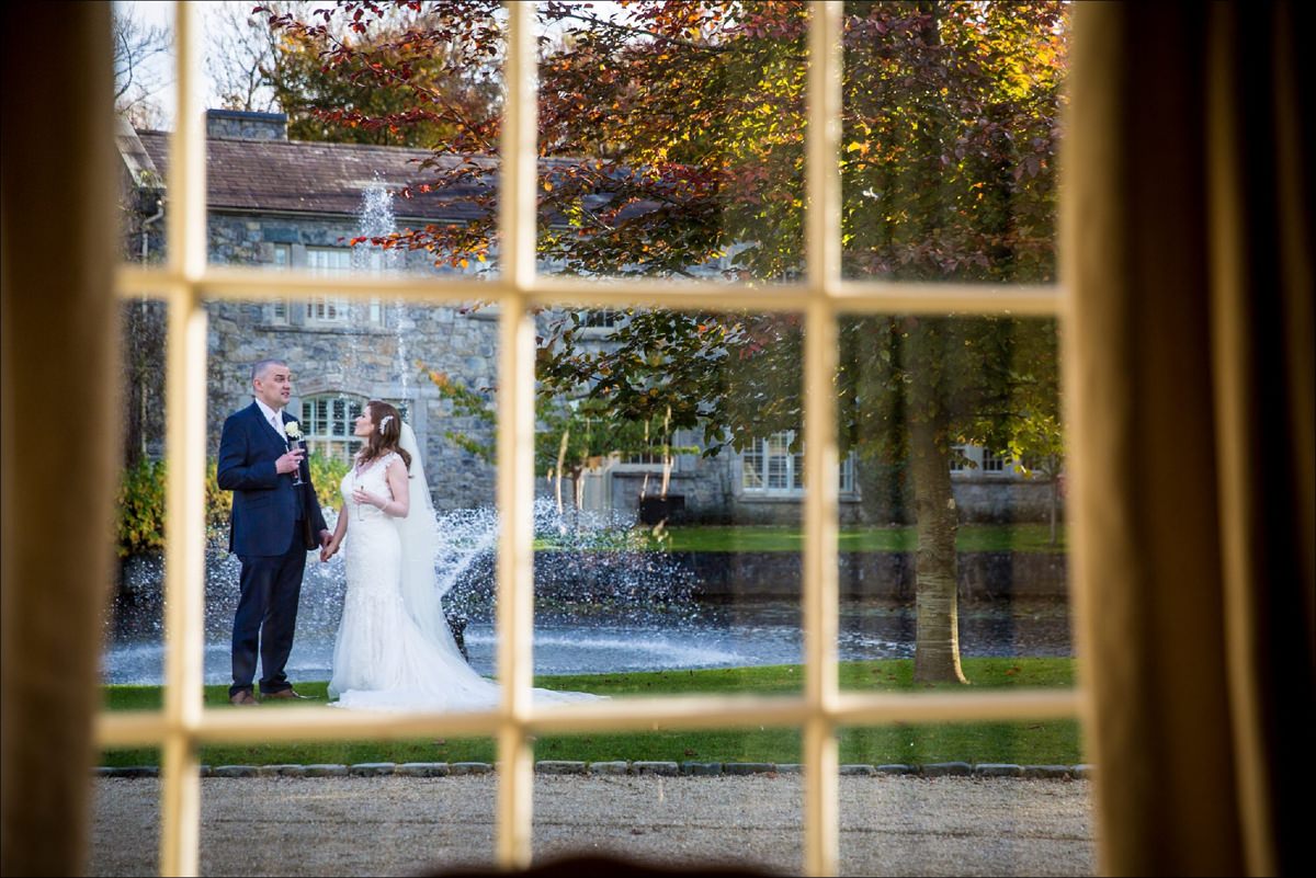 bride and groom chatting through a window at a Cliff at Lyons wedding in Kildare