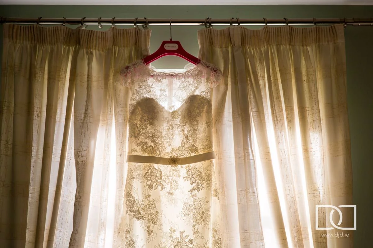 wedding dress hanging by a window at castle leslie co monaghan