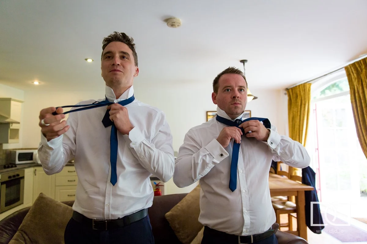 groomsmen doing their ties at their wedding at castle leslie co monaghan