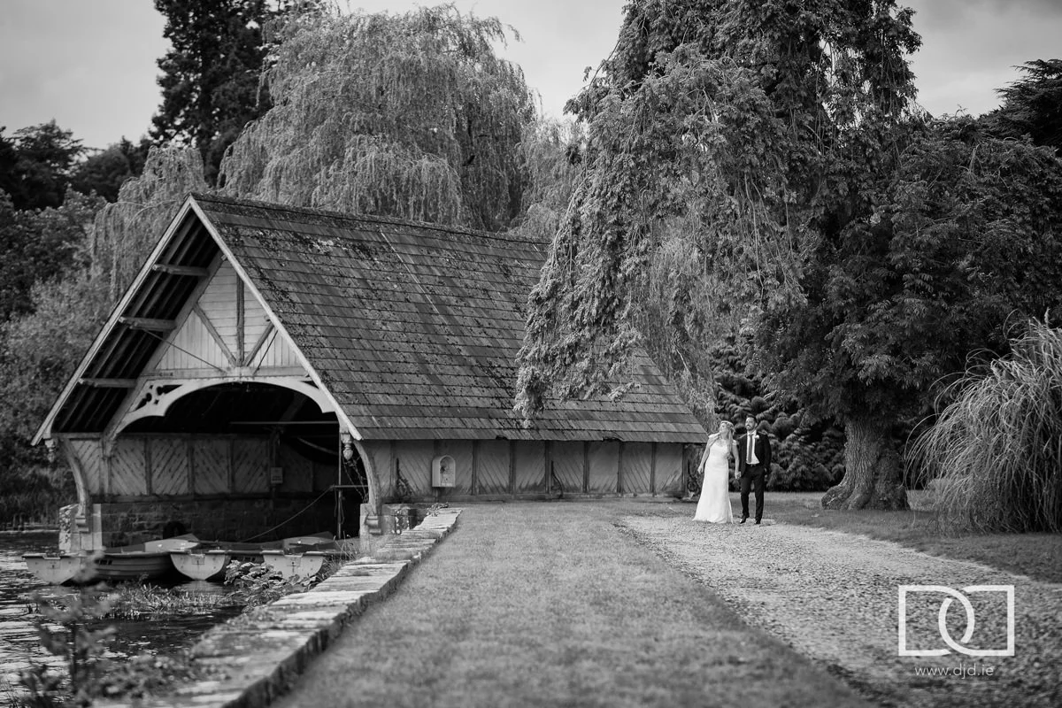 bride and groom walking by the boathouse at their wedding at castle leslie co monaghan