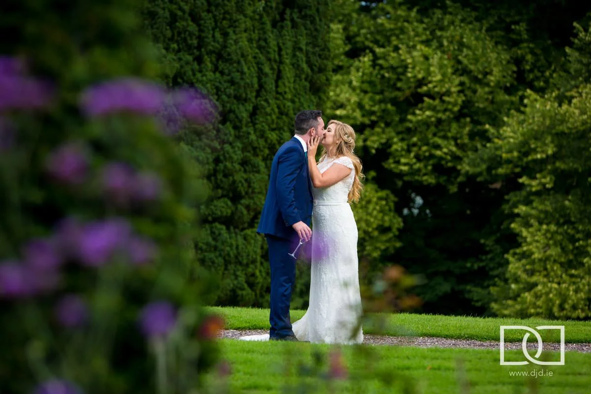 bride and groom kissing in the gardens at their wedding at castle leslie co monaghan