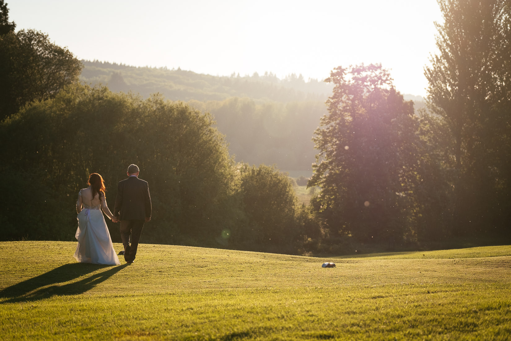 bride and groom walking into the sunset at cabra castle