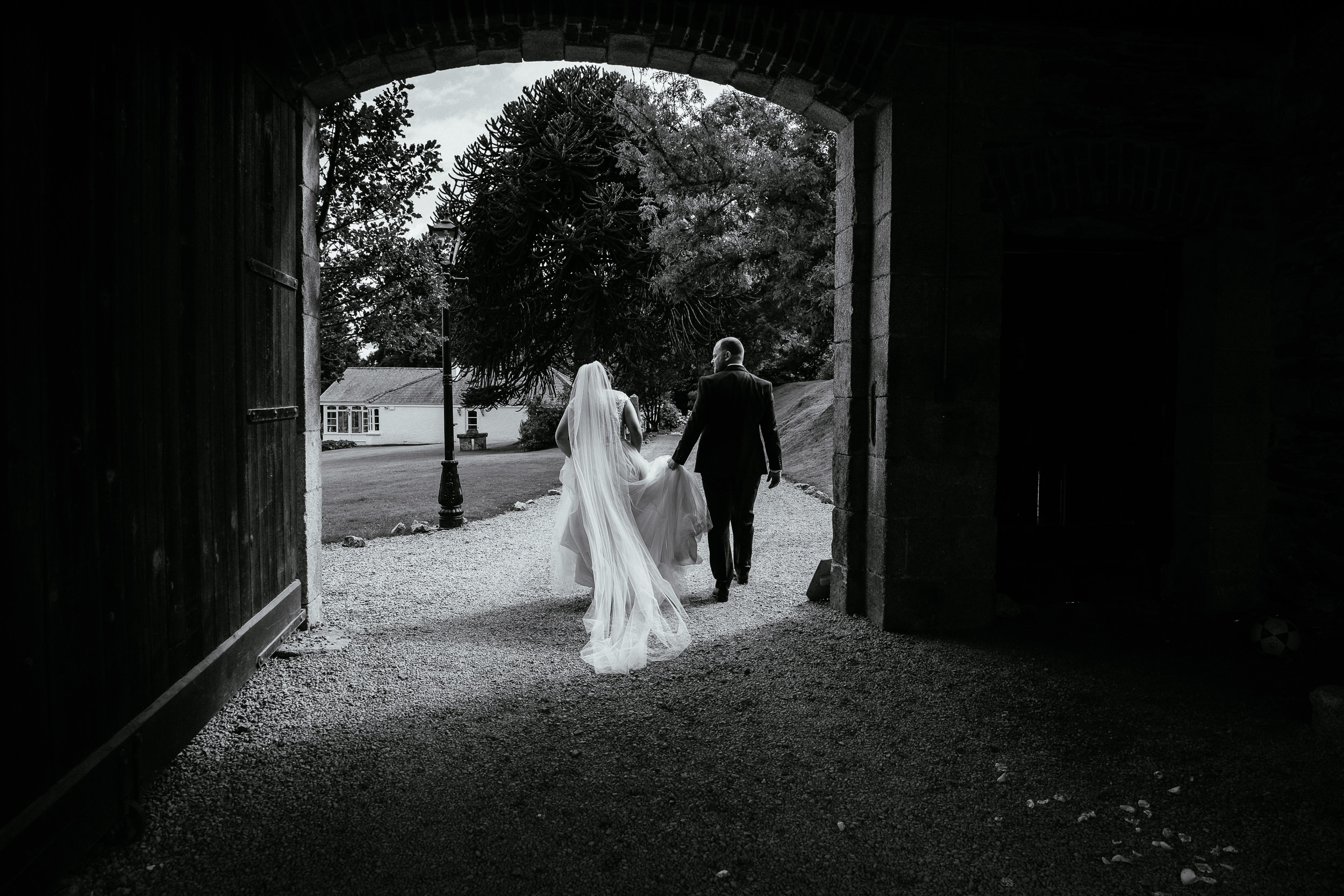bride and groom walking down avenue bride and groom sitting and standing in bar of ballybeg house