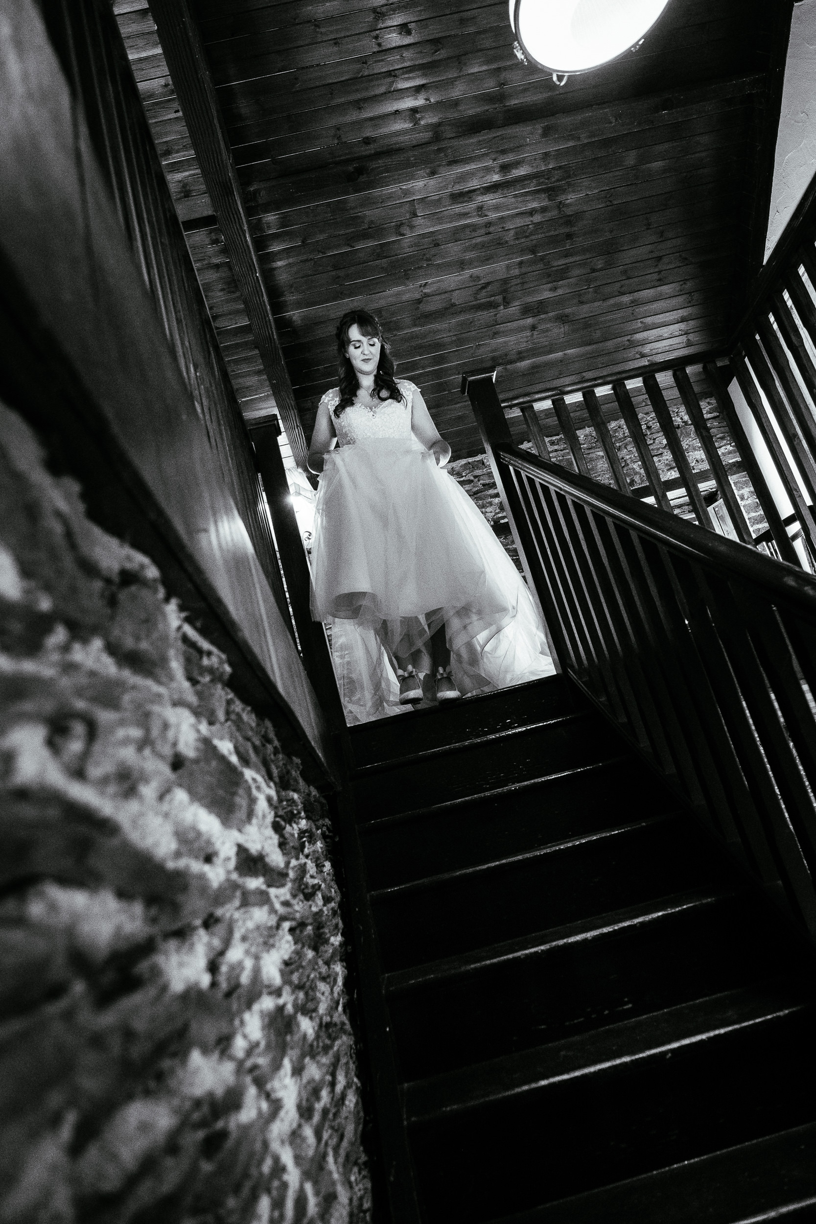 bride walking down stairs holding her dress
