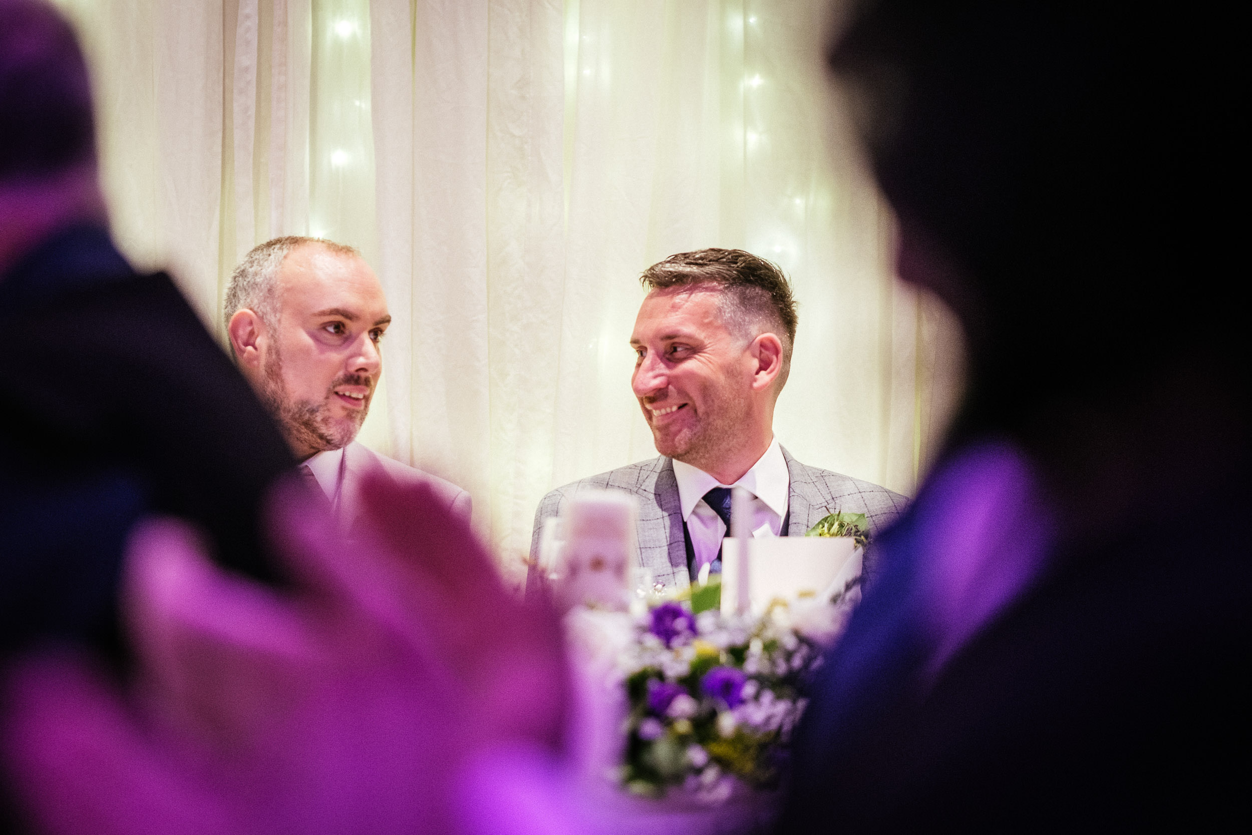 gay grooms laughing during a wedding speech