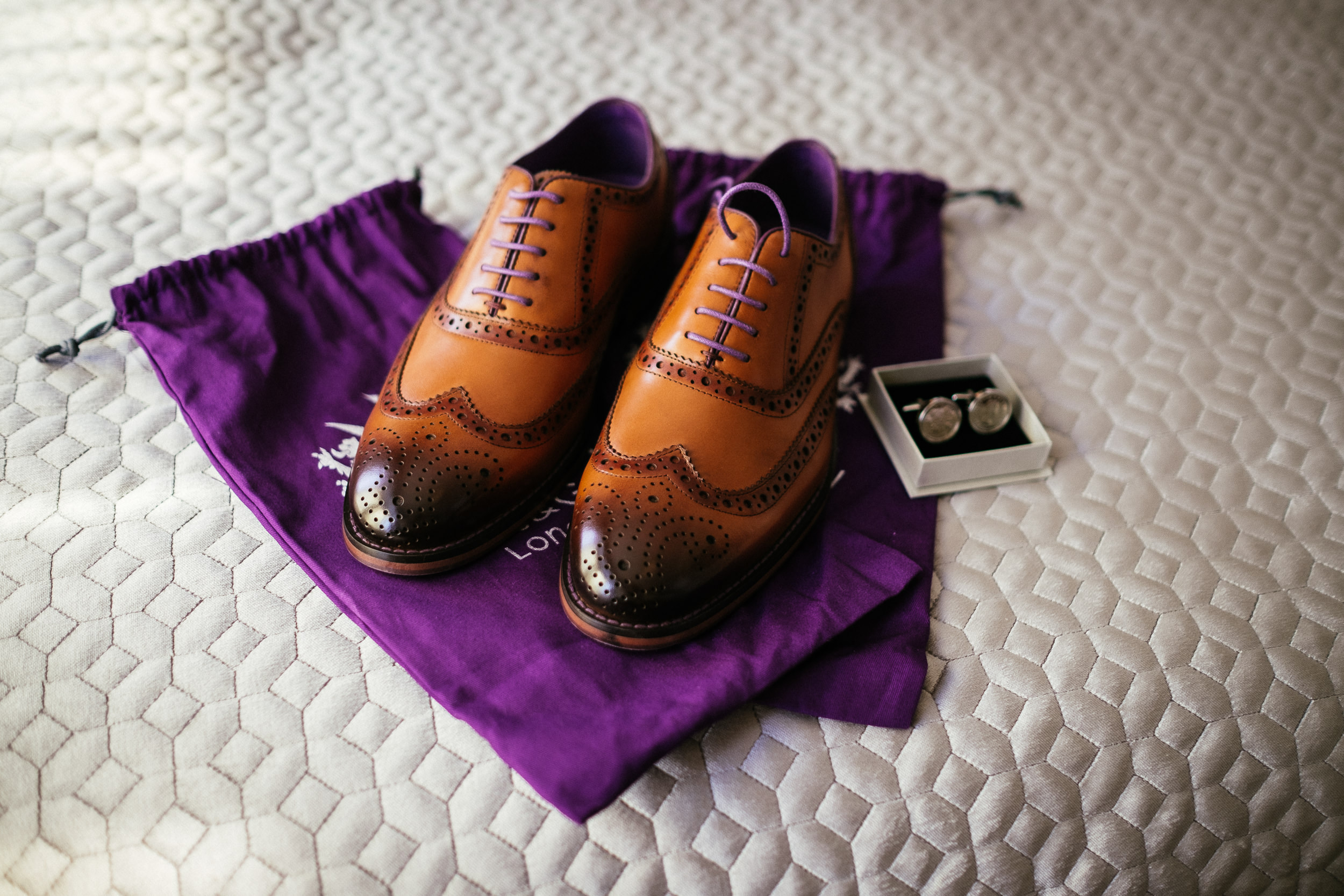 grooms shoes on bed