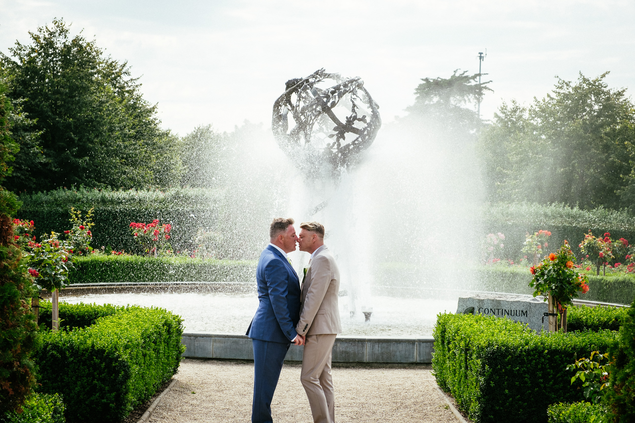 2 grooms kissing during their gay wedding