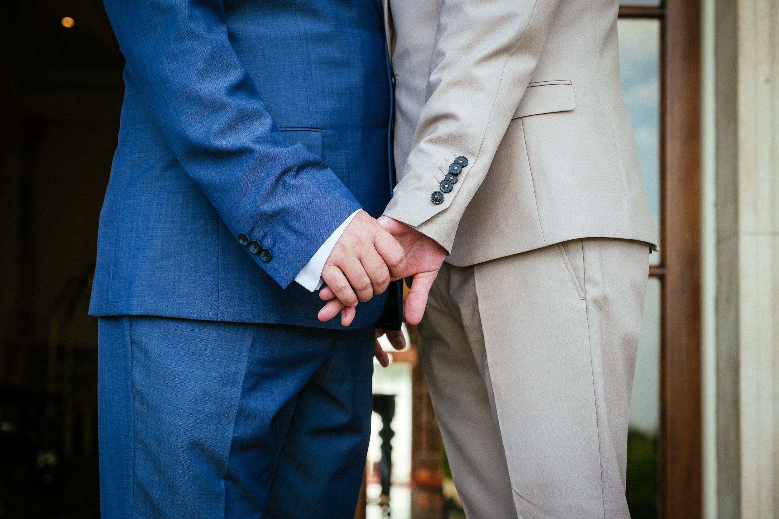 2 grooms holding hands during their gay wedding