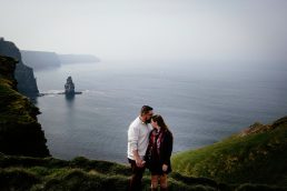 engaged couple kissiing at the Cliffs of Moher