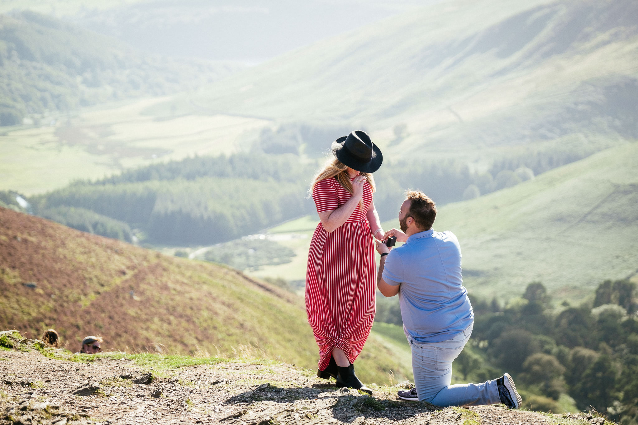 guy proposing to his girlfriend on a mountain top