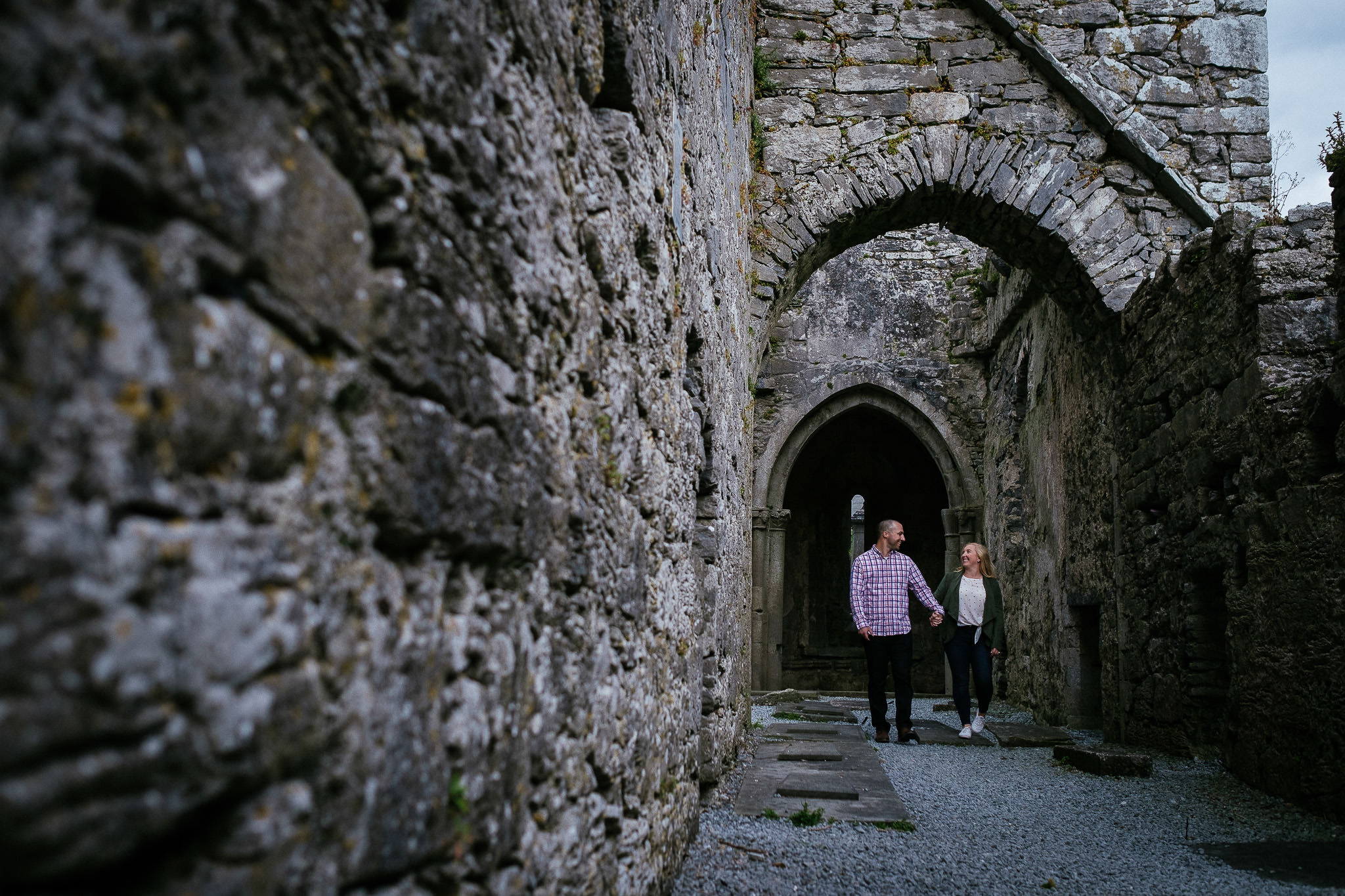 engaged couple walking through corcomroe abbey