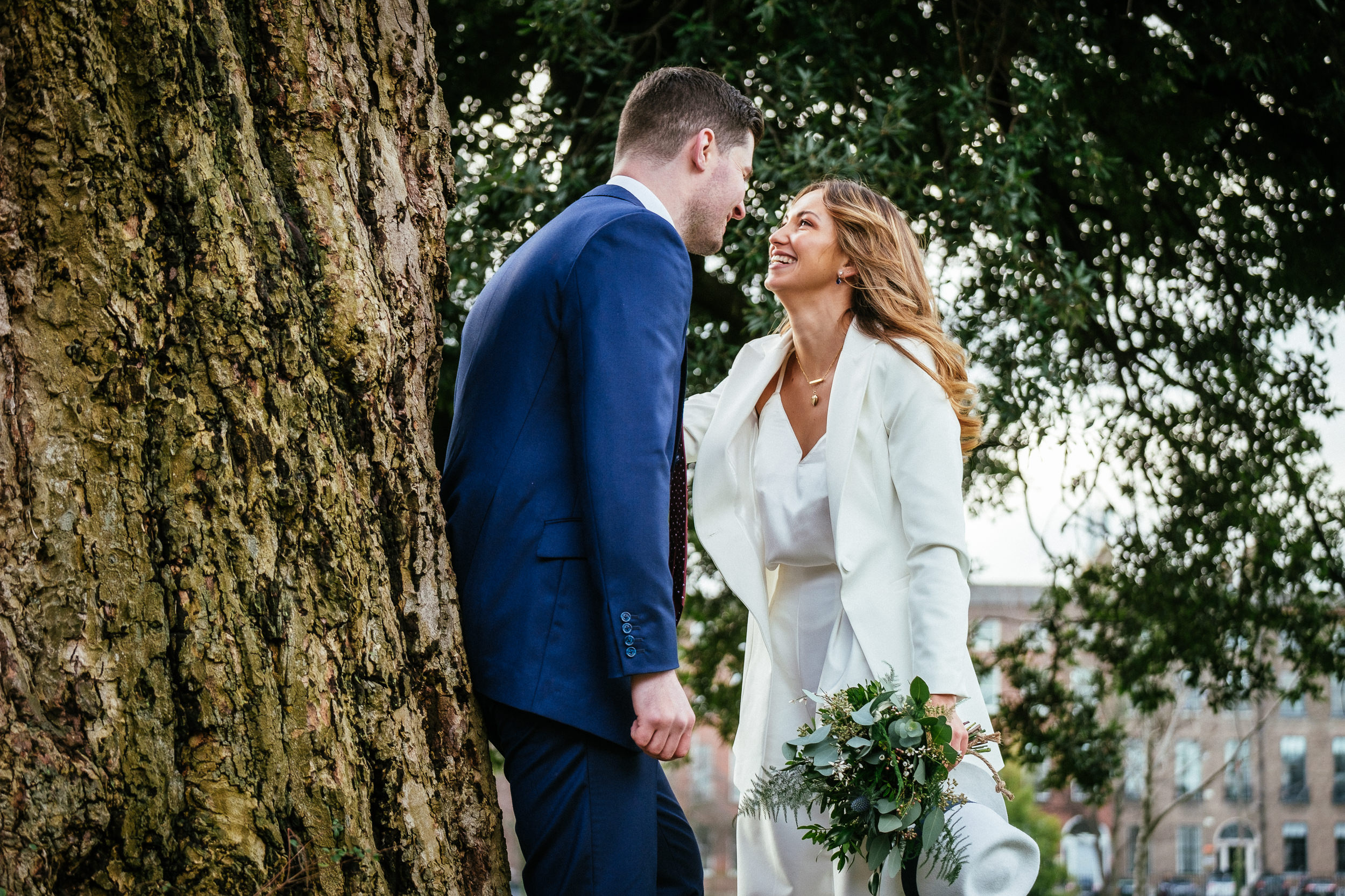 bride and groom kissing by a tree in Merrion Park Dublin after their Dublin registry office wedding