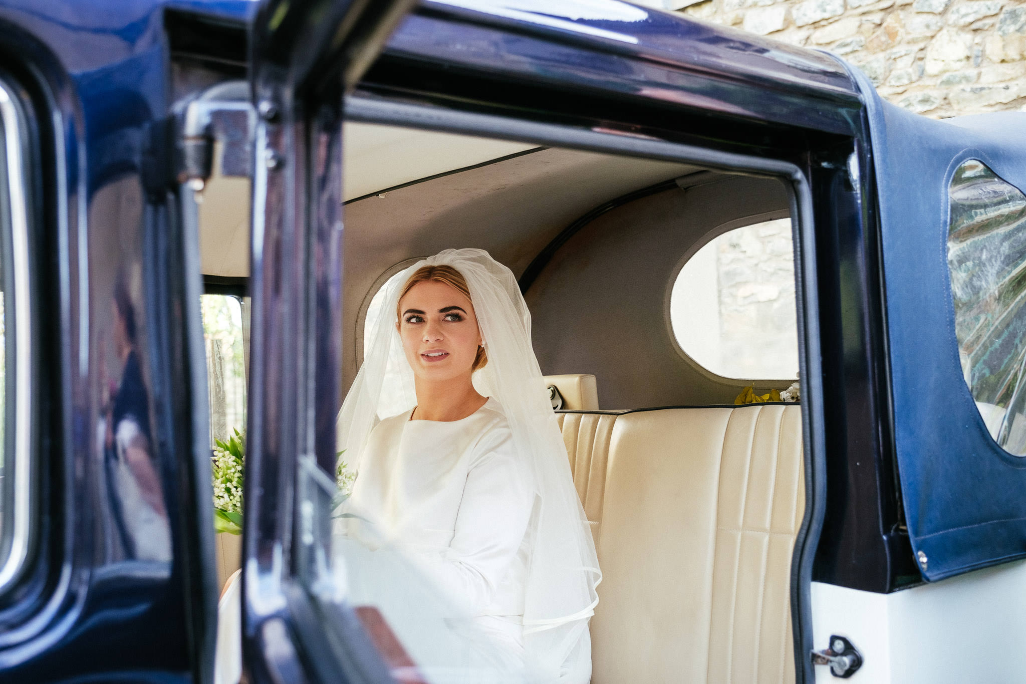 bride sitting in wedding car