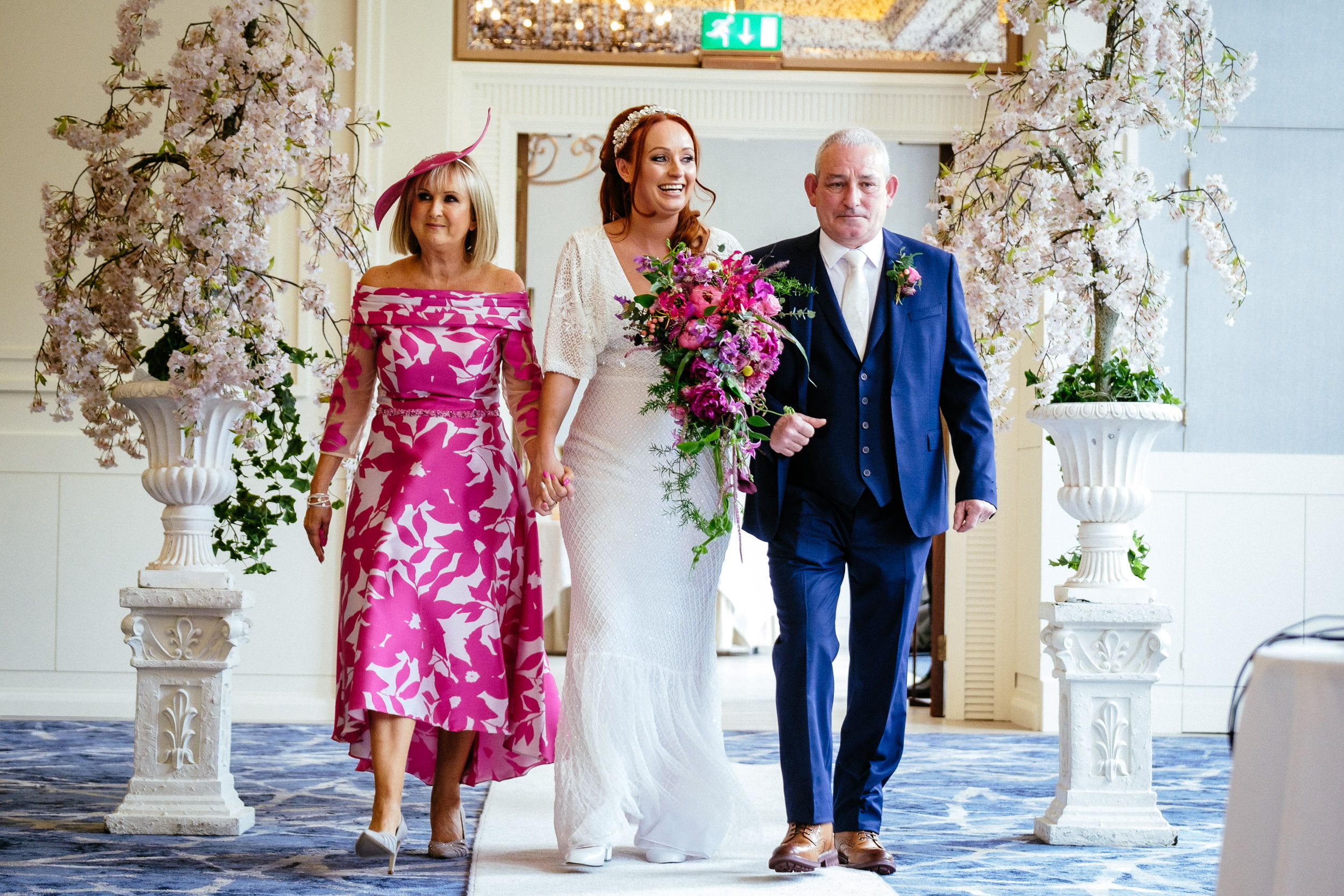 bride walking down the eaisle with her parenst at the Fota Island Resort Cork